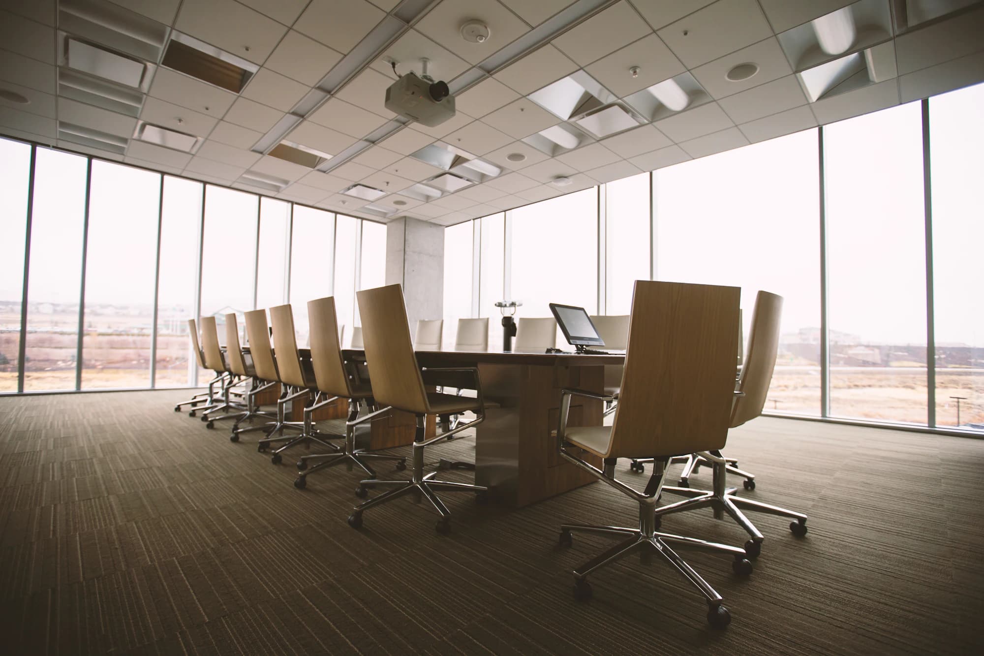 Corporate boardroom with a conference table, executive seating and floor-to-ceiling windows